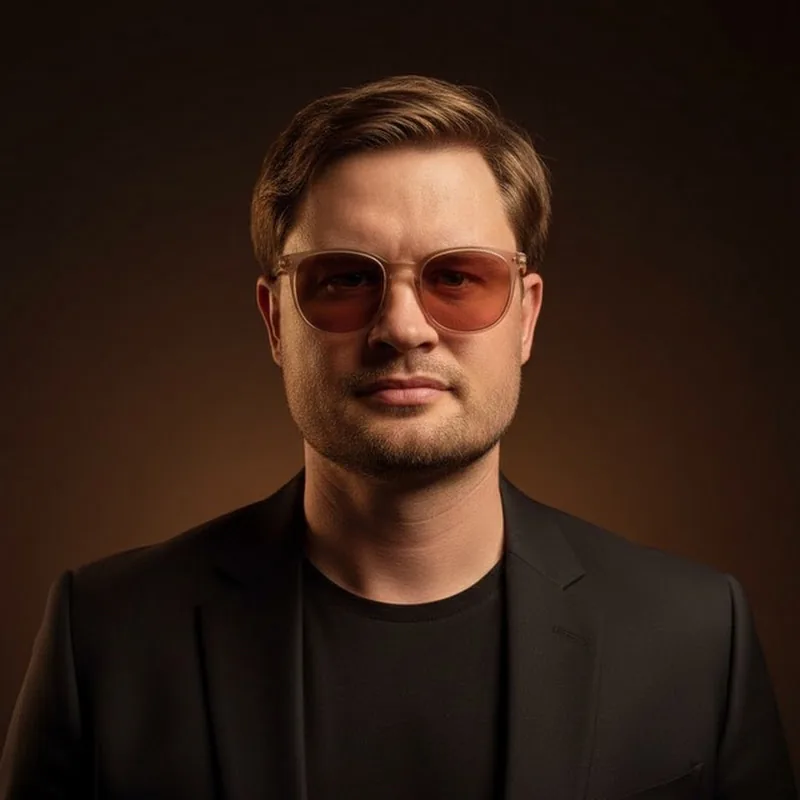 Valentin Moskalev in a black jacket and rose-tinted glasses